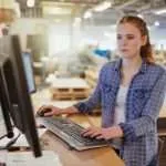 Una joven trabajando con un ordenador en la oficina de una imprenta